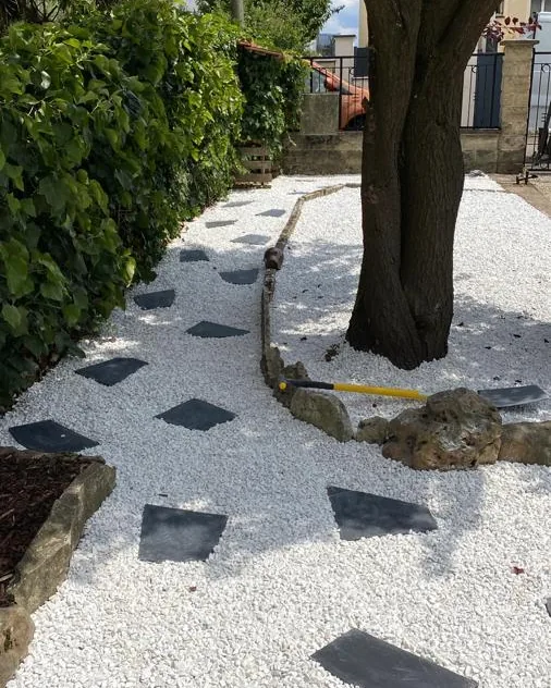 Après : jardin réaménagé avec gravier clair, pas japonais en ardoise et arbre conservé